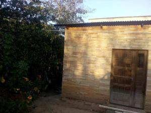 ein kleines Backsteingebäude mit einer Holztür in der Unterkunft Chalé Lameirao in Mulungu