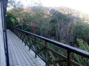 einen Balkon mit einem Zaun und einem Gehweg in der Unterkunft Chalé Lameirao in Mulungu