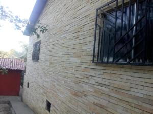 eine Ziegelmauer mit einem Fenster an der Seite eines Gebäudes in der Unterkunft Chalé Lameirao in Mulungu