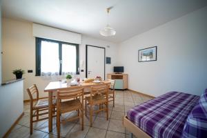 een eetkamer met een tafel en stoelen en een bed bij Residence Brenta in Bibione