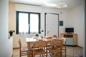 een eetkamer met een tafel en stoelen bij Residence Brenta in Bibione
