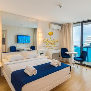 a bedroom with a large bed with a hotel sign on it at Beach Hotel Orbi City in Batumi