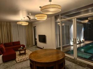 a living room with a couch and a table and a pool at Reflections by SOL Escapes near Cherai Beach in Pallipuram