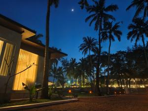 a night view of a house with palm trees at Reflections by SOL Escapes near Cherai Beach in Pallipuram
