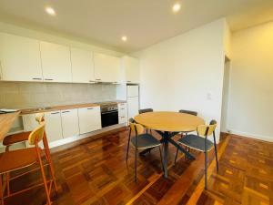 a kitchen with a wooden table and chairs at Sunny Escape - Ponta do Sol -- Vila Silva Upstairs in Ponta do Sol +9 photos