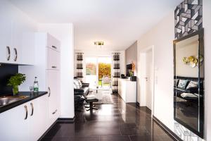 una cucina con mobili bianchi e un soggiorno di Blankwasserweg 57, "Amina 2" a Grömnitzerhagen