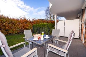 un tavolo e delle sedie seduti su un patio di Blankwasserweg 57, "Amina 2" a Grömnitzerhagen