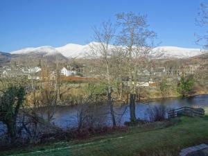 een rivier met sneeuw bedekte bergen op de achtergrond bij 10 Elm Court in Keswick