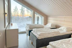 Holiday Villa Rento في Himos: ثلاثة أسرة في غرفة مع نافذة كبيرة +39 صورة