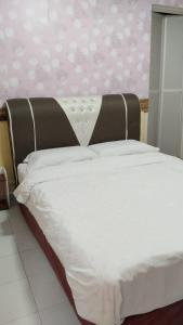 Una cama blanca con cabecera marrón en un dormitorio. en hen hen monthly rent, en Kampong Saleng