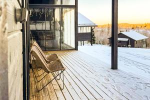 Holiday Villa Rento في Himos: سطح خشبي مع مقعد على المنزل