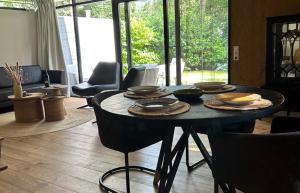 a table with plates and bowls on it in a living room at Bosvilla Berk met een Jacuzzi in Geesbrug +26 photos