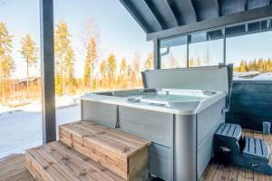 Holiday Villa Rento في Himos: وجود حوض استحمام ساخن على سطح السفينة بجوار النافذة