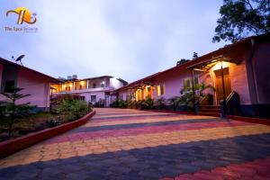 a cobblestone walkway in front of a building at The Lyca Resorts in Jog Falls