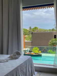 a bedroom with a view of a pool from a window at Pousada Villas - Bonito in Bonito