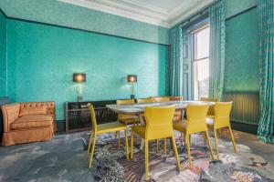 a dining room with a table and yellow chairs at 12A Queens Gardens, St Andrews in St. Andrews