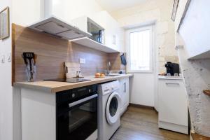 a kitchen with a washer and dryer in it at Le Petit Rochalais - Appartement cosy avec terrasse et parking in La Roche-Chalais