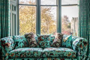 a blue couch sitting in front of a window at 12A Queens Gardens, St Andrews in St. Andrews