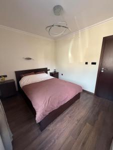 a bedroom with a bed with a pink comforter at Pasarel House in Pasarel