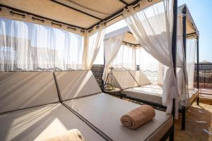 Pokój z zasłonami, łóżkiem i oknem w obiekcie Dar Khmissa Riad & Spa w Marakeszu