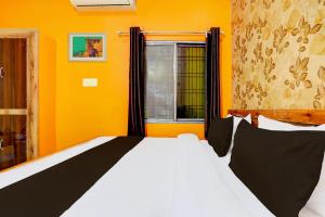 a bedroom with a white bed and a window at Hotel O Value in Jabalpur