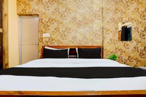 a bedroom with a large white bed and wallpaper at Hotel O Value in Jabalpur +21 photos