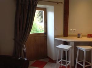 a kitchen with a window and a table and stools at Le Colombier de la Graverie in Senots