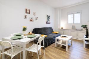 a living room with a table and a couch at Le Petit Rochalais - Appartement cosy avec terrasse et parking in La Roche-Chalais