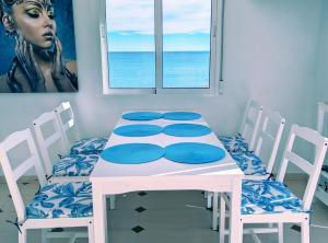 a white table and chairs with a table and a window at AGAMARI La Mata Torrevieja sun apartment in Torrevieja