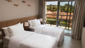 2 Betten in einem Hotelzimmer mit Balkon in der Unterkunft Pousada Village Premiere in Fernando de Noronha + 49 Fotos