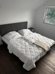 a bed with a white comforter in a bedroom at Loftbude in Hürth