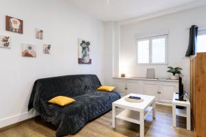 a living room with a couch and a table at Le Petit Rochalais - Appartement cosy avec terrasse et parking in La Roche-Chalais