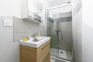 a bathroom with a sink and a shower at Le Petit Rochalais - Appartement cosy avec terrasse et parking in La Roche-Chalais
