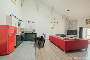 a living room with a red couch and a kitchen at Superbe appartement type loft en duplex rue Buat in Châlons-en-Champagne +32 photos