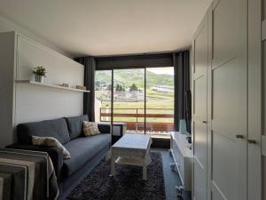 Una sala de estar con un sofá y una ventana. en Studio cosy pour 4 avec balcon et Wi-Fi, accès direct aux pistes - FR-1-602-59, en Arette
