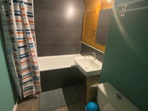 Un baño con lavabo, bañera e inodoro. en Studio cosy pour 4 avec balcon et Wi-Fi, accès direct aux pistes - FR-1-602-59, en Arette