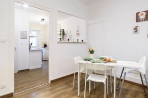 a white dining room with a white table and chairs at Le Petit Rochalais - Appartement cosy avec terrasse et parking in La Roche-Chalais +22 photos