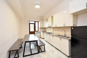 埃里温Perfect的厨房配有木桌和黑冰箱。