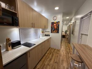 eine Küche mit Holzschränken und einem Gemälde an der Wand in der Unterkunft The Zanzibar Beach House-West in Paje