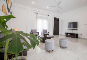 sala de estar con 2 sillas, mesa y TV en Elora Kandana, 