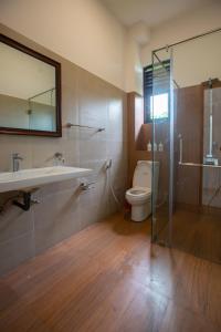 Un baño con inodoro, lavabo y ducha. en Elora Kandana,  25 fotos más