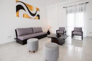 una sala de estar con un sofá y dos sillas en Elora Kandana, 