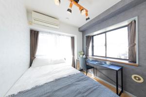 a bedroom with a bed and a desk and a window at The Nest Koenji Cozy Stay near Station Easy Access to Shinjuku in Tokyo