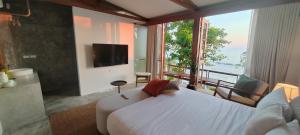 a bedroom with a white bed and a large window at Pebble Lanta - Seaview Stay in Ko Lanta