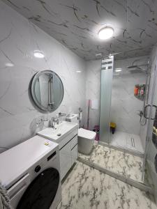 Un baño con lavabo, inodoro y espejo. en Kvartira, en Irvadan