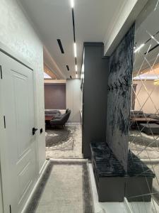 Un pasillo con una puerta y un banco negro. en Kvartira, en Irvadan