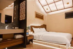 a bedroom with a bed and a mirror at Chaozhou Wuta Tanju Designer Courtyard Retreat - Inside Ancient City, Near Paifang Street, Guangji Bridge & Kaiyuan Temple - Kung Fu Tea & Coffee - Pet Friendly, Pick-up Service & Free Breakfast in Chaozhou