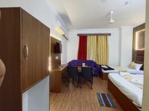 a hotel room with a bed and a desk and a bedroom at Hotel classic inn in Hyderabad