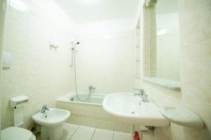 a bathroom with a sink and a toilet and a tub at In pieno centro vicino al mare in Ischia Town