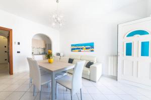 a dining room with a table and white chairs at In pieno centro vicino al mare in Ischia Town